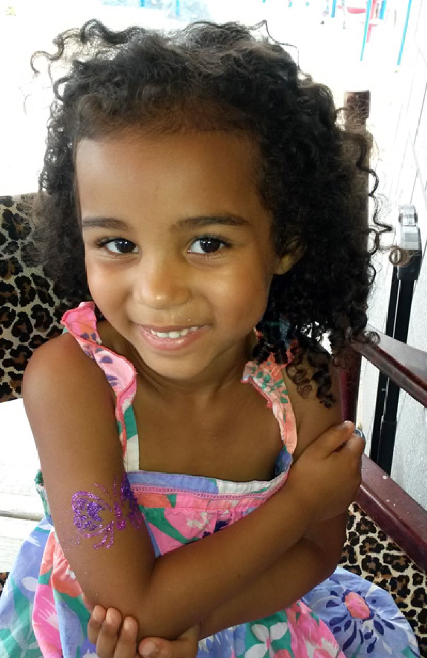 Young lady loving her butterfly glitter tattoo at pool party in Raleigh, NC